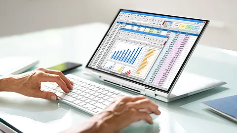 Analyst reviewing casting cost per kg charts and costing sheets on a laptop