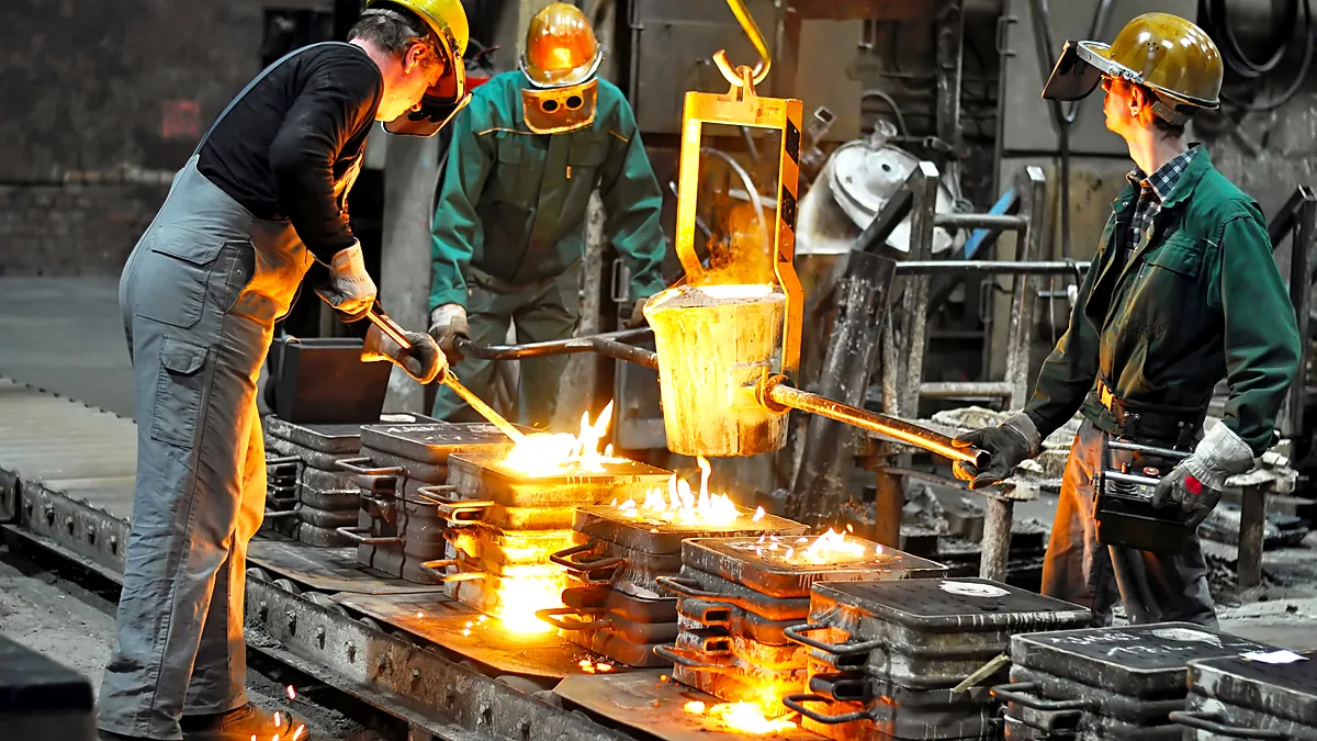 Foundry team pouring molten metal into moulds on the shop floor